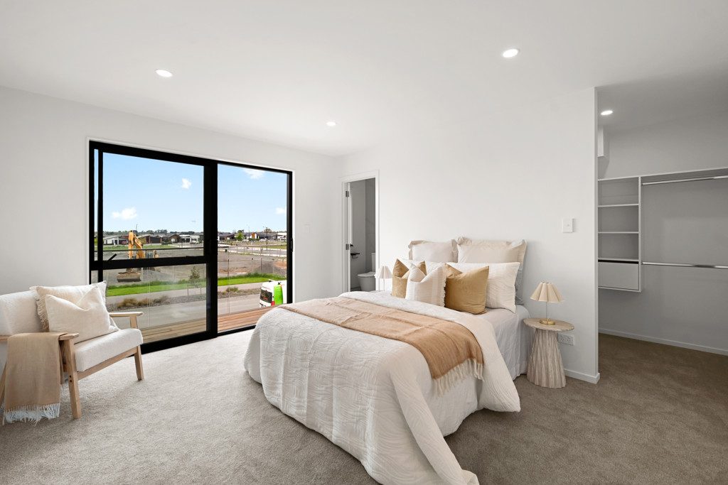 Bright bedroom with large windows and a walk-in wardrobe