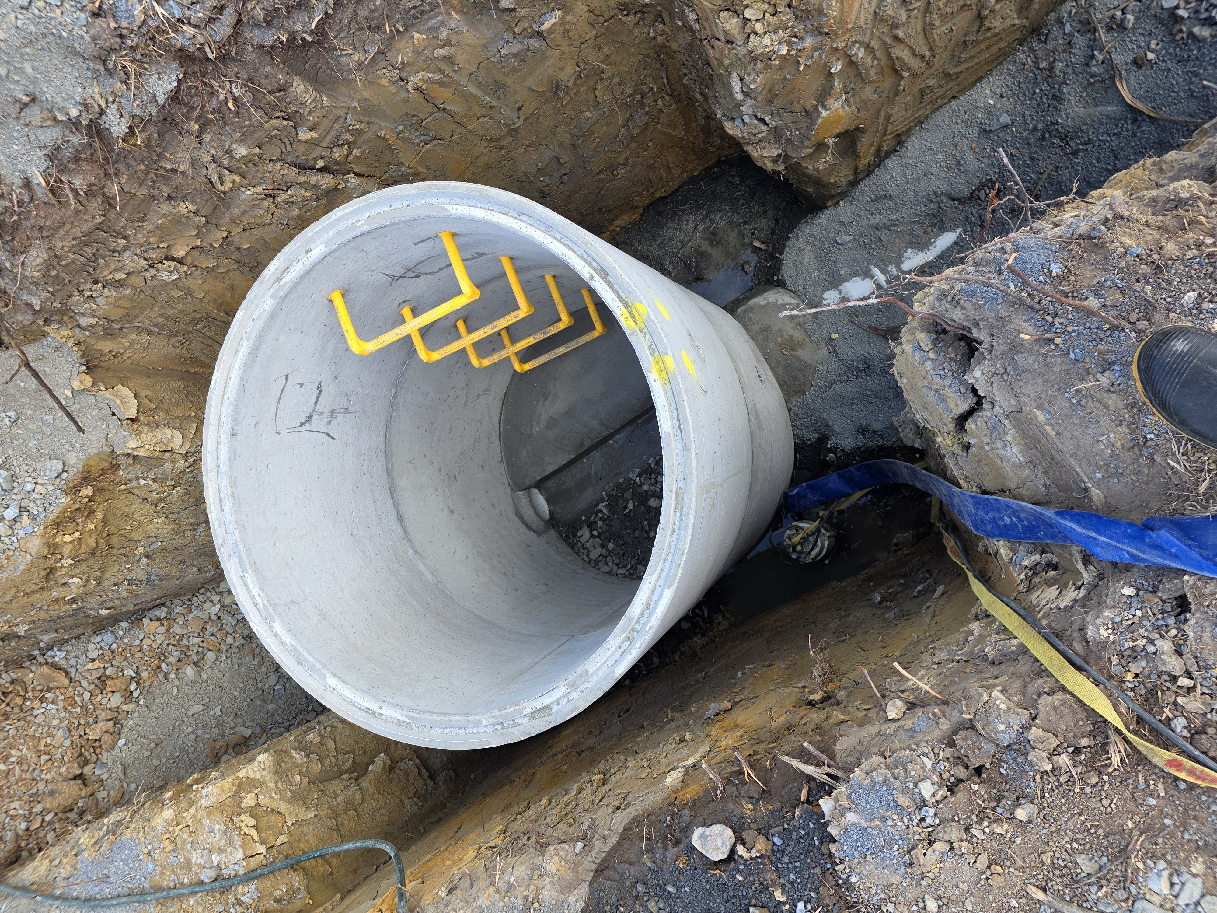 Concrete drainage manhole being installed in an excavated trench